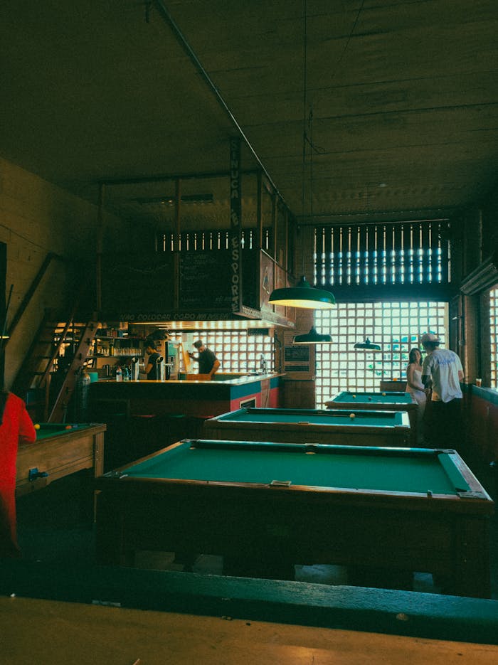 Cozy indoor bar with pool tables and patrons enjoying a casual game night.