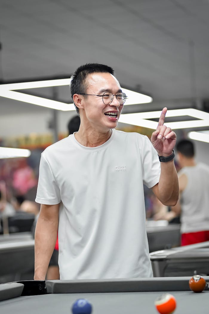 Smiling man enjoying billiards in an indoor venue in Hanoi, Vietnam.
