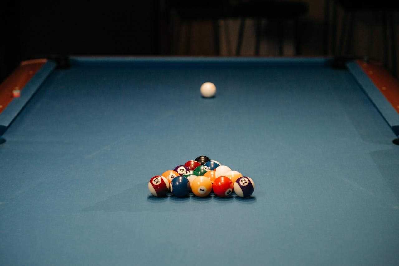 Colorful billiard balls arranged on a blue table ready for the break shot.