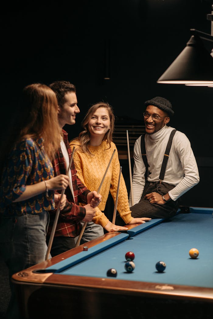 A diverse group of friends playing billiards, enjoying leisure time together.
